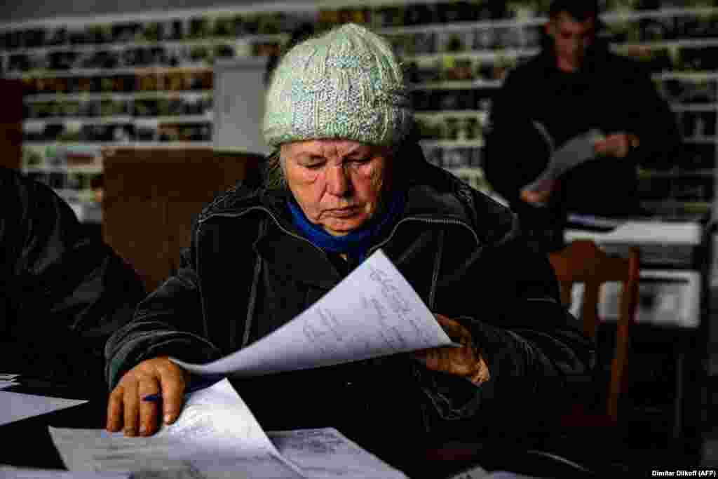 Anna Sukhova, 78, fills out paperwork for war crimes investigators before submitting her DNA to confirm the identity of her dead brother. 