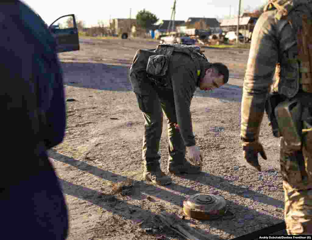 A soldier inspects a damaged anti-tank mine in Snihurivka. Exploded bridges and military positions that these Ukrainian forces discovered as they advanced make it clear the Russian forces left the area "systematically," Dubchak said. 