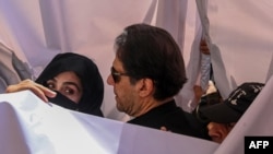 Former Pakistan Prime Minister Imran Khan (center) with his wife, Bushra Bibi (left), arrive to appear at a high court in Lahore in May 2023. 