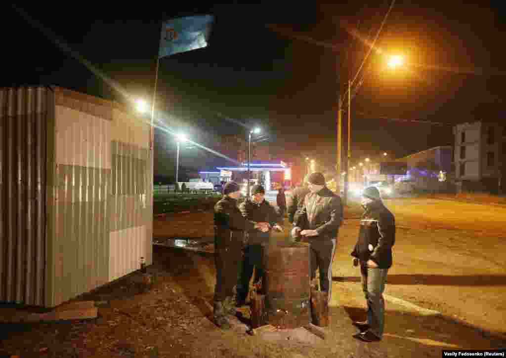 Crimean Tatars warm themselves around a fire while guarding their neighborhood on March 9. Ukraine’s interim Prime Minister Arseniy Yatsenyuk vowed Ukraine would not relinquish "an inch" of its territory as Russia’s takeover of Crimea solidified and life became increasingly dangerous for locals opposed to the illegal annexation. 