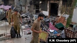 Police officers walk through the rubble of homes vandalized by a Muslim mob in a Christian area in Jaranwala, Faisalabad district, Pakistan, on August 17. 