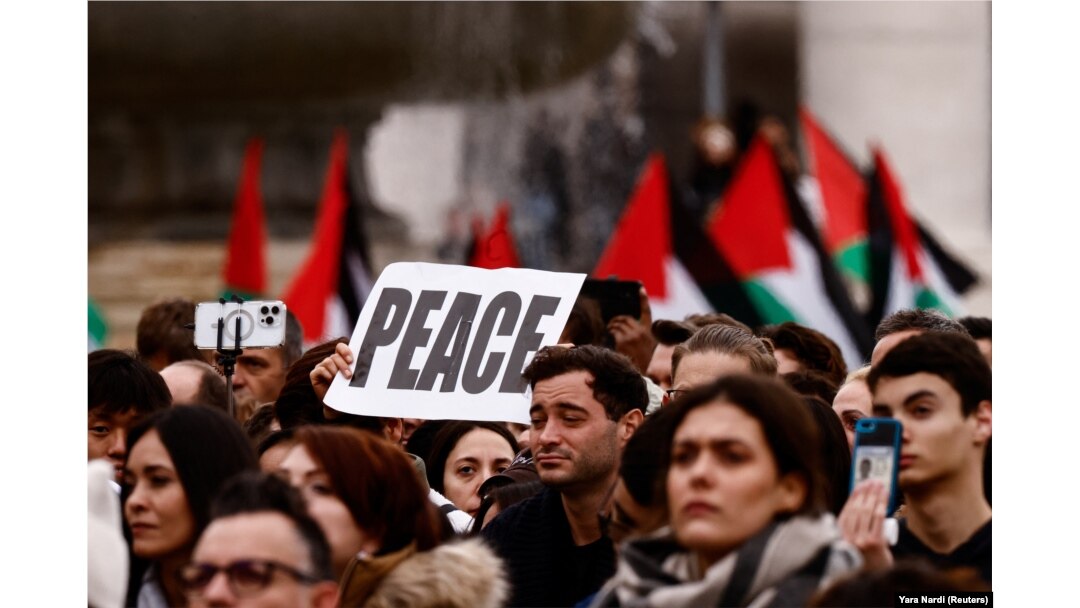 Plakat i palestinske zastave među grupom koja se okupila kako bi čula božićnu poruku pape Franje u Vatikanu, 25. decembra 2023.