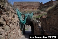 To enter the complex, people must walk through the crumbling quadrangular tower.