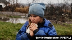 A 9-year-old girl named Sofiyka hugs her guinea pig during her evacuation from Makiyivka, in Ukraine's eastern Luhansk region, on November 19, 2022.