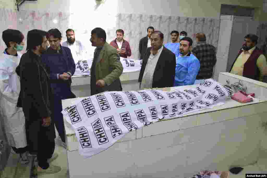 People gather around the bodies of victims waiting to be identified at the hospital in Quetta. &nbsp;