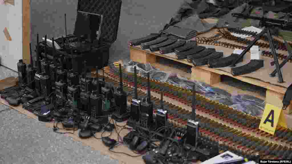 Radio communications equipment along with bullets and cartridges were displayed. A total of eight people have been arrested so far, according to Veton Elshani, a top regional police official, and access to the village remains blocked. "The police still haven't finished their work, they don't know when it will happen, maybe today during the day," he told RFE/RL.