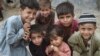 Afghan children pose for a photo at an Afghan refugee camp in Karachi on September 21.