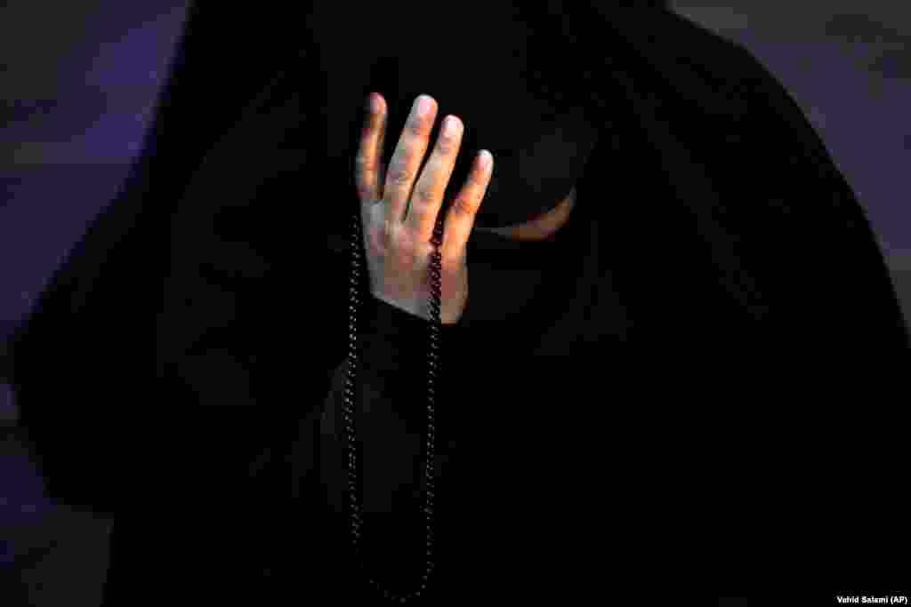An Iranian woman prays for President Ebrahim Raisi in Tehran on May 19 after it was reported that the helicopter carrying Raisi and his entourage crashed in northwestern Iran. Iranian Supreme Leader Ayatollah Ali Khamenei declared five days of mourning after the bodies of Raisi, 63, and Foreign Minister Hossein Amir-Abdollahian, 60, were found at the site of a helicopter crash on May 20.