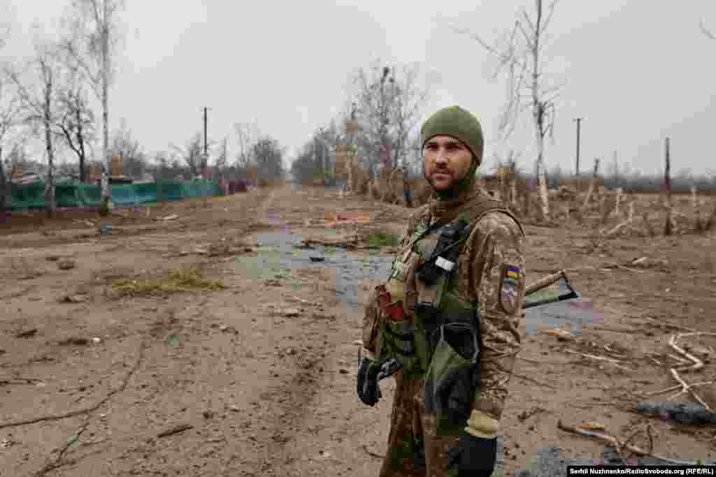 На первом изображении: украинский военный в селе Тетеревское, расположенном к северо-западу от Киева. Март 2022 года. На втором изображении: та же местность в марте 2024 года. Все фотографии Тетеревского за 2022 год, включённые в эту галерею, были сделаны во время боёв между российскими и украинскими военными. Фотографии 2024 года сняты в конце марта &nbsp;