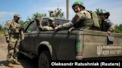 Ukrainian soldiers pose for a photograph near the front line on June 13 in the eastern Ukrainian village of Neskuchne, which Kyiv says it has retaken from Russian forces amid a counteroffensive. 