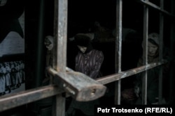 Mannequins representing prisoners inside a prison car