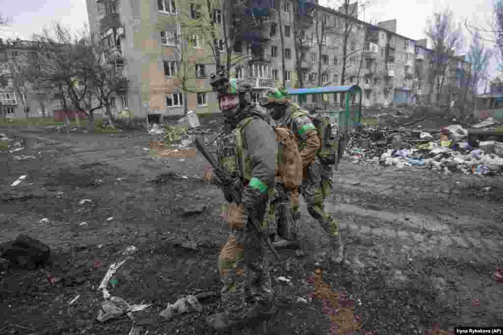 Ukrainian troops walk through a Bakhmut neighborhood on April 12. Ukrainian soldiers have described Russian assaults on Bakhmut as "human wave" attacks, comparable to the enormously costly tactics used by the Soviet Red Army during World War II. 