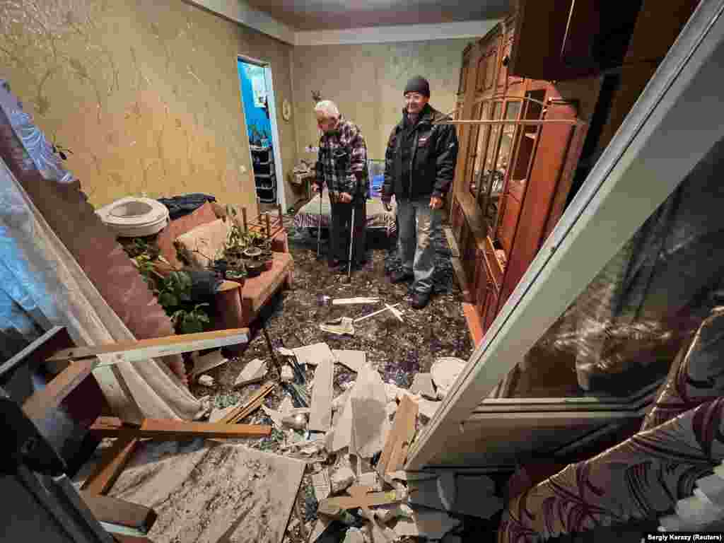 71-летний Пётр Хомын осматривает квартиру, в которой из-за удара вылетели окна, повреждена мебель