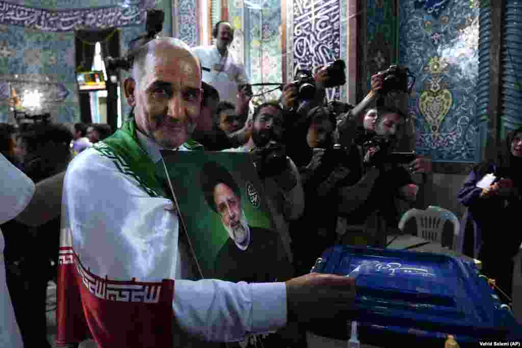 A man casts his ballot as he holds a portrait of Raisi. Raisi, who many Iranians refer to as the "Butcher of Tehran" for his alleged role in the mass execution of political prisoners in 1988 when he was Tehran's deputy prosecutor, died along with Foreign Minister Hossein Amir-Abdollahian and several other officials when their helicopter crashed on May 19.