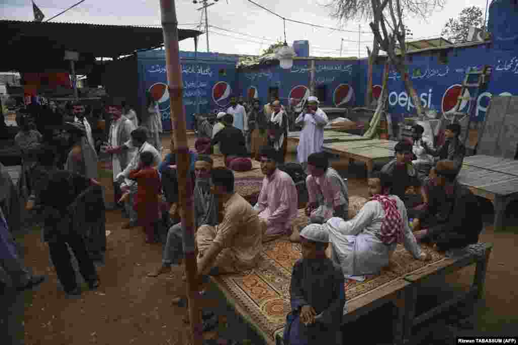 Afghans gather at a tea shop in the refugee camp in Karachi. Afghans have poured into Pakistan in their millions during decades of successive wars, many living in aid camps with restricted access to education, health care and employment. 