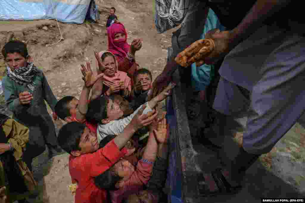 Volunteers distribute bread among people affected by floods near the village of Shirjalal.