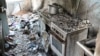 In an apartment building in the center of Luch, a kitchen remains under the rubble from a bombed-out roof.