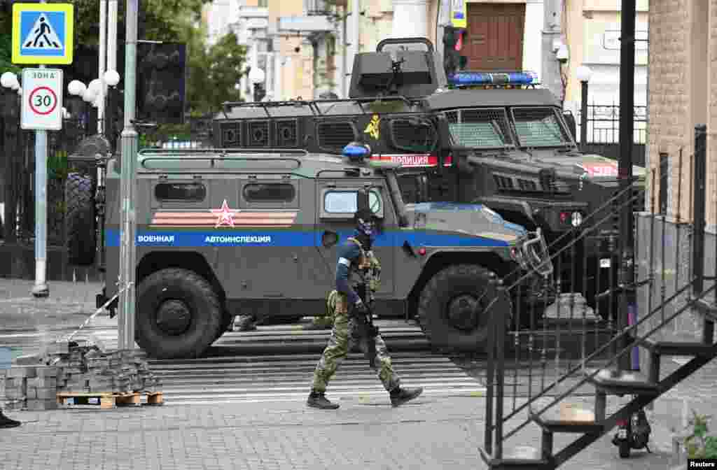 A Wagner fighter seen in front of armored vehicles reportedly belonging to the Russian military in Rostov-on-Don. 