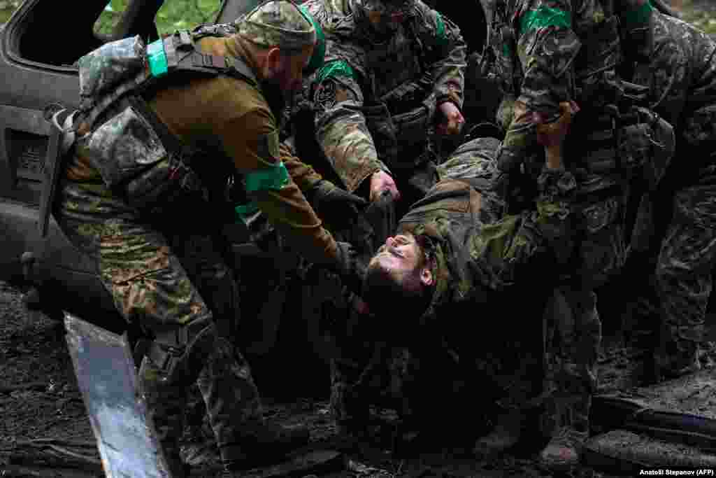 Ukrainian soldiers carry an injured comrade. Kyiv admits that its forces have paid a heavy price defending "Fortress Bakhmut," a city that held around 70,000 people before the Russian invasion. 