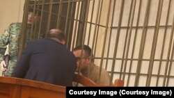 Ukrainian citizen Volodymyr Kadaria in a defendant's cage in a Bishkek courtroom on March 1.