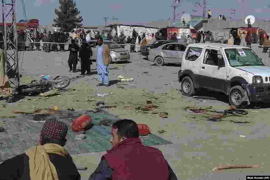 Security officials examine the scene of a bomb blast in Pakistan&#39;s Balochistan Province on February 7. Two bomb blasts killed more than 20 people and are raising concerns over security in the nuclear-armed South Asian country as it prepares for a general election.