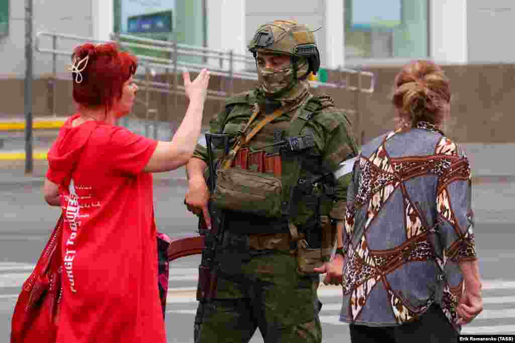 A woman speaks to an armed man in Rostov-on-Don after exiting a bus. 