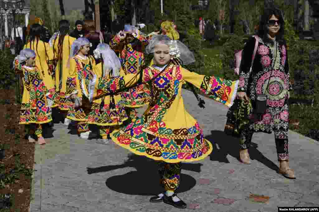 A Tajik girl spins in her colorful traditional dress in Dushanbe.