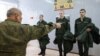 Russian conscripts try on uniforms at a local draft office before departing for military service. (file photo)