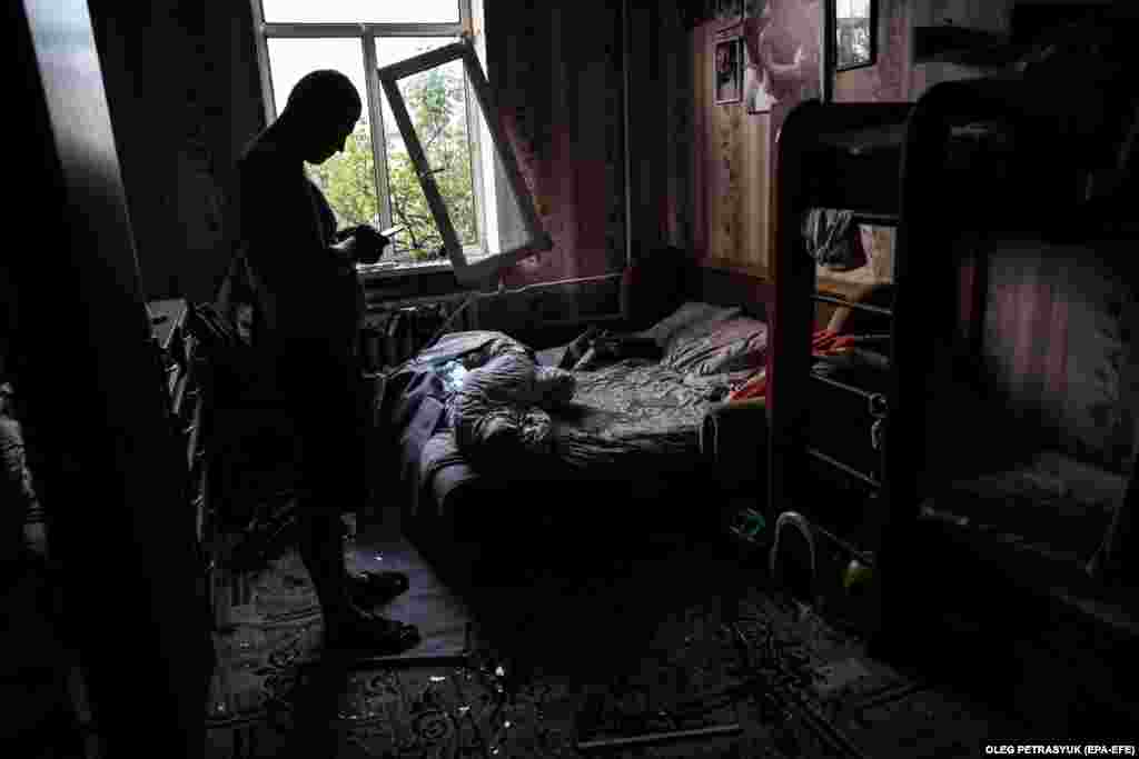 Kyiv resident Dmytro checks his phone after surveying the damage inside his flat. "Damage was recorded in the Darnytskiy, Solomyanskiy, and Shevchenkivskiy districts in Kyiv as a result of falling missile pieces," said Ihor Klymenko, Ukraine's minister of internal affairs.