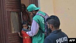 An official (center) from the Pakistan Bureau of Statistics goes door-to-door as part of the first-ever digital national census in Pakistan, in Karachi on March 1.