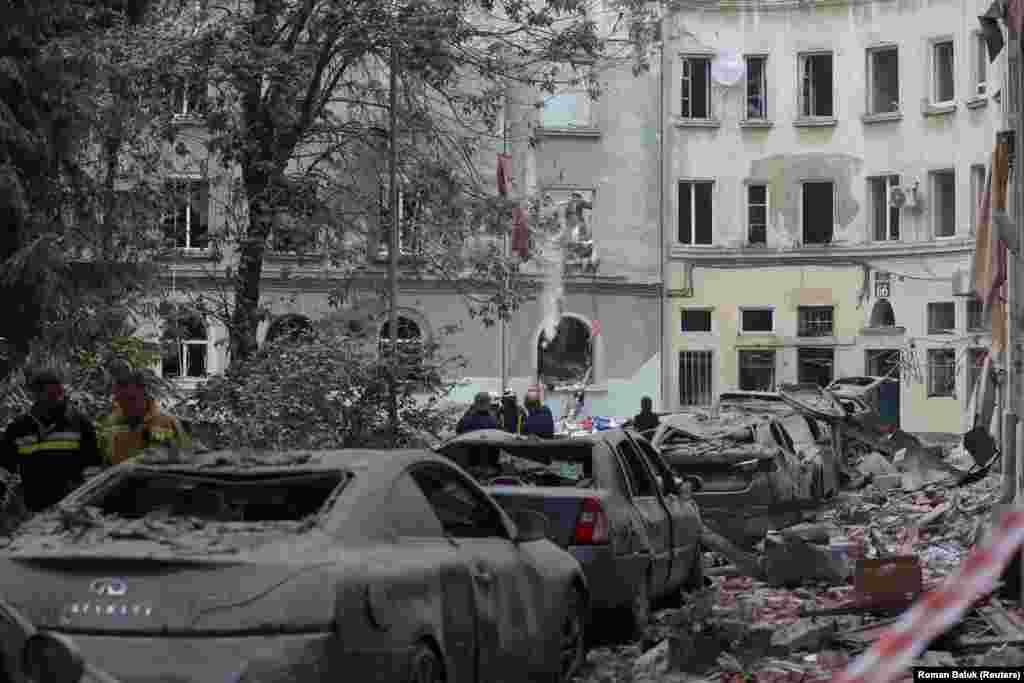 Rescue workers at the scene of a rubble-covered street. Lviv Mayor Andriy Sadovyi said around 60 apartments and 50 cars were damaged. 