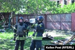 Firefighters outside a destroyed home in Kharkiv