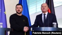 German Chancellor Olaf Scholz and Ukraine's President Volodymyr Zelenskiy shake hands at a press conference in Berlin on February 16.
