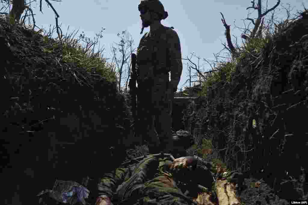 A Ukrainian soldier stands above a dead Russian soldier in a recently captured trench near Bakhmut, in eastern Ukraine, on July 4. Kyiv's counteroffensive against Russian forces has been "particularly fruitful" in the past few days, Oleksiy Danilov, secretary of Ukraine's National Security and Defense Council, said on July 5. His comments come after Ukrainian President Volodymyr Zelenskiy said on July 4 that his troops had made progress after a "difficult" week.