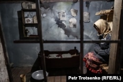 An installation depicts camp life for a prisoner with a baby.