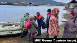 Residents of a village in Russia's Yakutia region are evacuated on May 13.