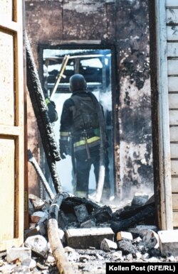 A firefighter enters a house in ruins and smoldering after being hit with a Russian glide bomb.
