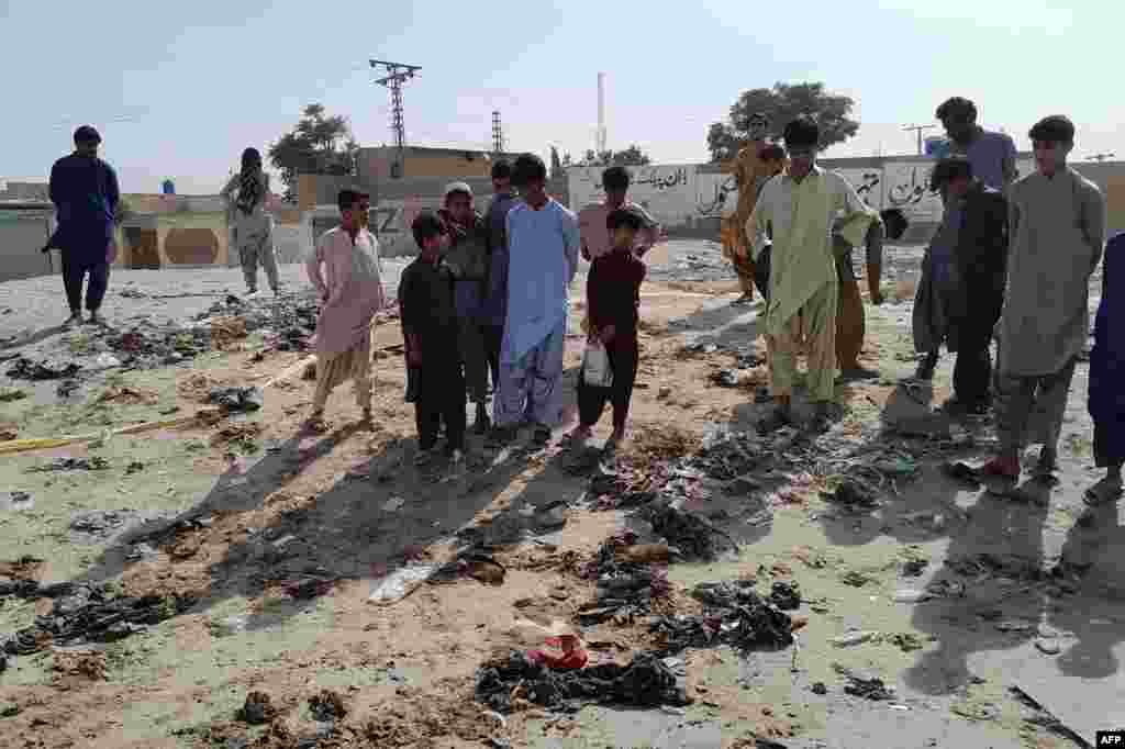Local residents stand at the site of the suspected suicide attack where some 500 people had gathered to celebrate the Prophet Muhammad&#39;s birthday. The day is known as Mawlid al-Nabi, and is often celebrated by distributing free meals to the poor. &nbsp;