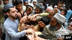 Men collect free bread from a distribution point in Peshawar, Pakistan, on April 3. The latest data forecast 27 percent inflation in the impoverished Islamic nation for 2023 and warned that unemployment will continue to rise.