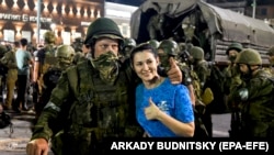 A woman poses with a Wagner Group fighter as he prepares to leave downtown Rostov-on-Don, southern Russia, on June 24.