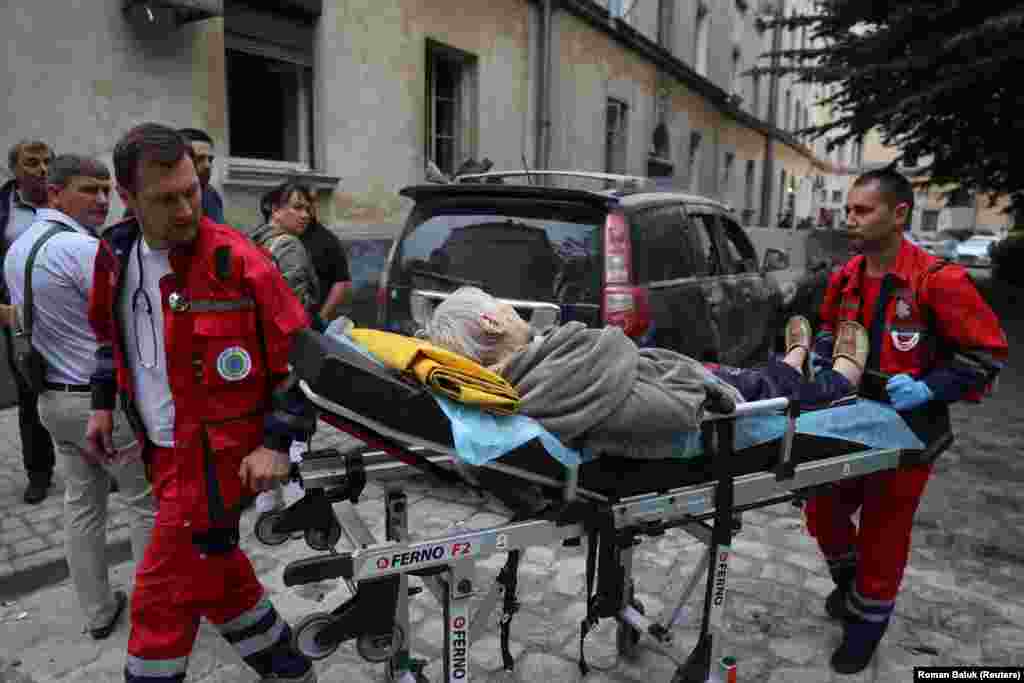 Paramedics carry an injured person from the scene.