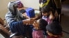 A health worker administers polio drops to a child during a door-to-door vaccination campaign in Karachi in October 2023. 