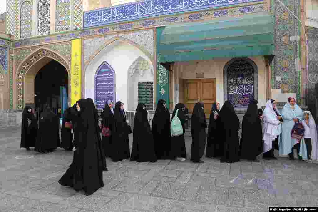 Iranians stand in a lie as they wait to vote at a polling station. All four names on the ballot have been vetted and approved by the Guardians Council, an unelected constitutional watchdog whose members are directly and indirectly appointed by Khamenei. 