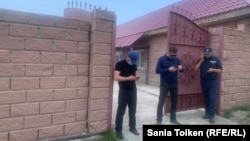 Police stand outside Marat Zhylanbaev's home in Astana on May 23.