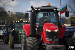 Farmers drive their tractors to block trucks crossing the Danube Bridge, which marks the border between Bulgaria and Romania, in a protest in late March against the duty-free import of grain coming from Ukraine into the EU.
