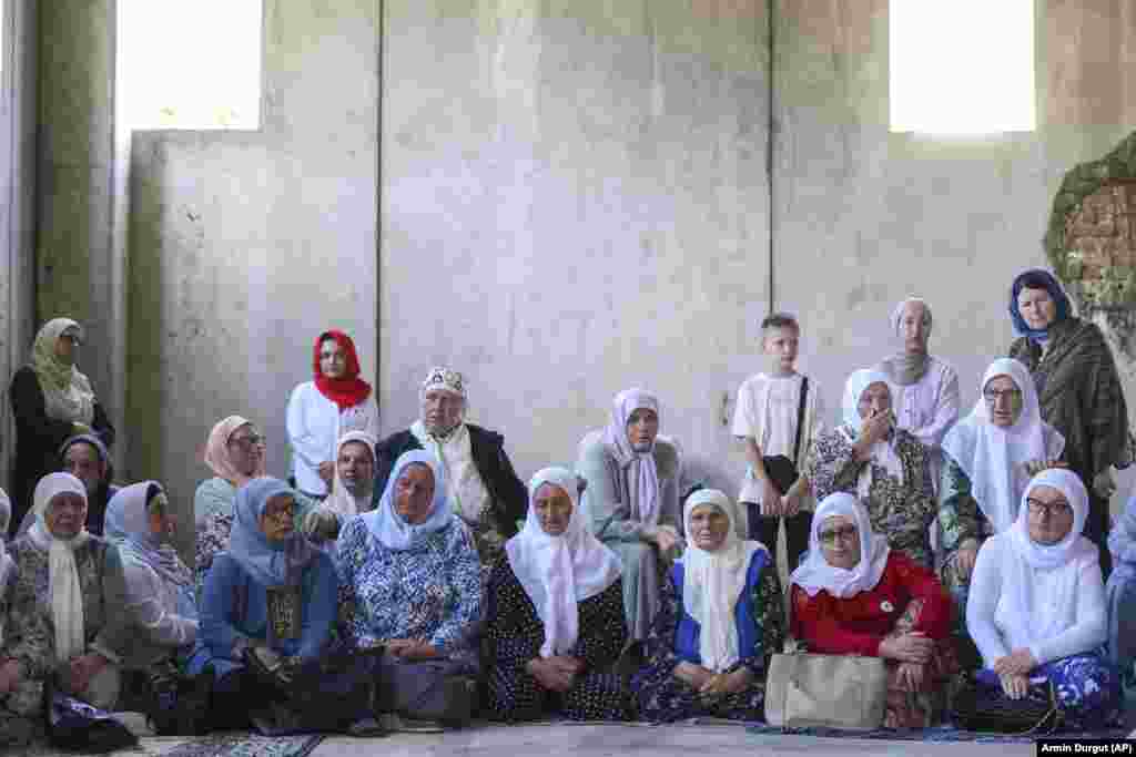 Muslim women pray next to 30 coffins containing the remains of their loved ones in Potocari, Bosnia-Herzegovina, on July 9. Their family members were victims of the 1995 Srebrenica genocide. The remains were to be buried on July 11 following a commemorative ceremony marking the 28th anniversary of the massacre, Europe's only acknowledged genocide since World War II.