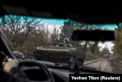 A Ukrainian soldier rides along a road in a BMP-1 armored fighting vehicle amid Russia's attack on Ukraine in the town of Avdiyivka on October 17.