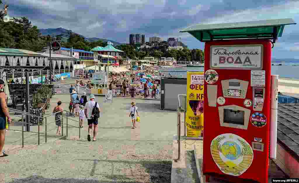 Tourists enjoy the sights along the beach at Alushta, located on the Crimean Peninsula's southern coastline. The peninsula, which is internationally recognized as Ukrainian territory, has been occupied by Russia since its illegal annexation and takeover in 2014. 