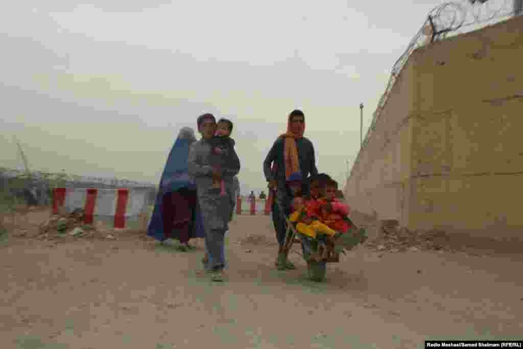 An Afghan boy ferries young children in a wheelbarrow at the border in Chaman, which is also known as the Friendship Gate. Pakistan is home to more than 4 million Afghan migrants and refugees, about 1.7 million of them undocumented, Islamabad says, although many have lived in Pakistan for their entire lives. &nbsp;