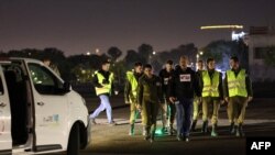 Israeli soldiers await the arrival of hostages by helicopter near Tel Aviv on November 30. Seniors, women, and children have been the priority so far in negotiations for the release of hostages.